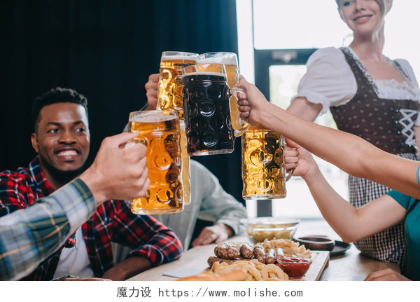 举杯庆祝的朋友欢快的多元文化朋友在酒吧庆祝十月节时，会喝杯啤酒